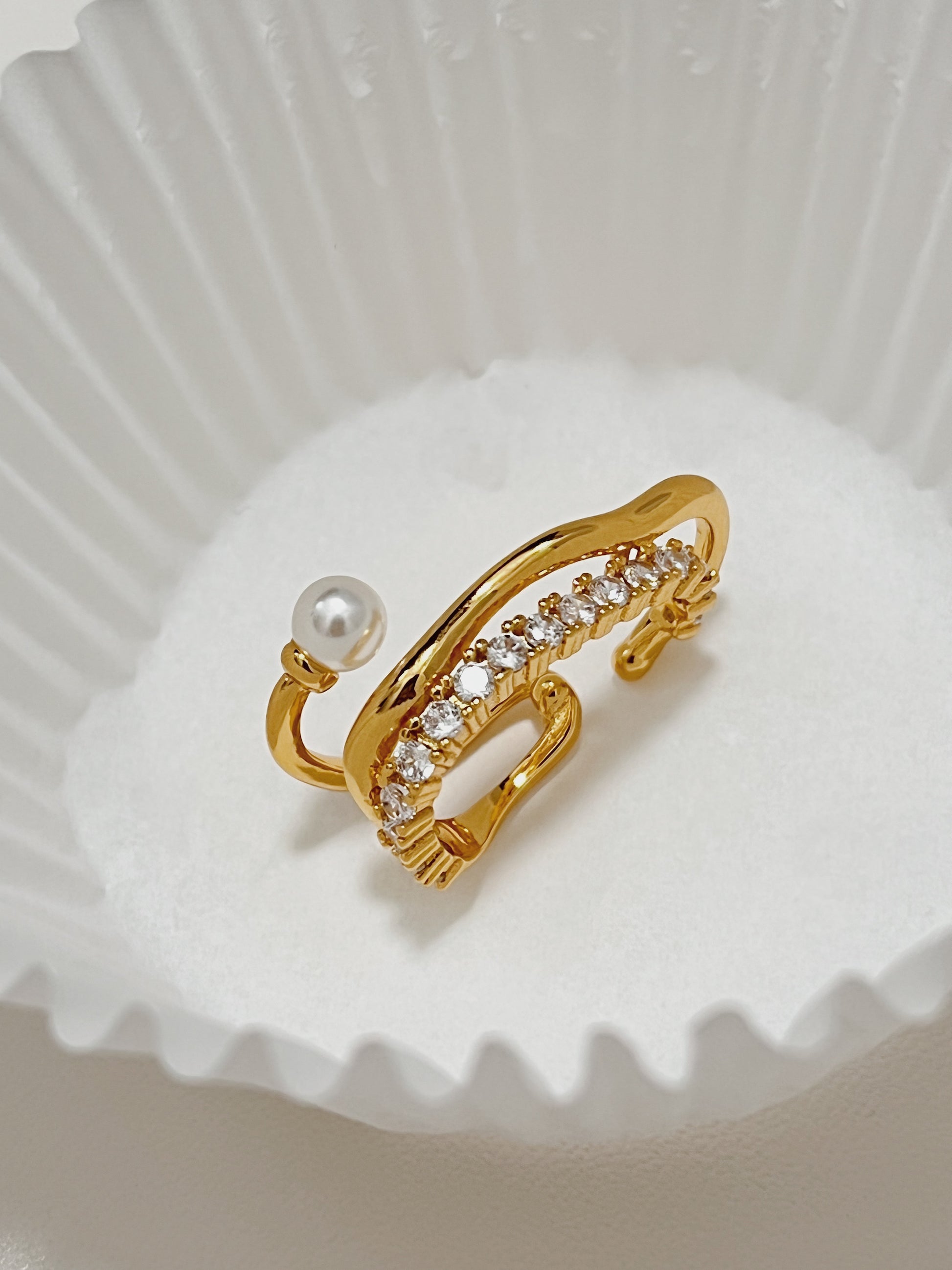 Close-up photograph of the ornate Cassidy Gold Cuff Earring with a genuine round freshwater pearl and pave cubic zirconia, displaying its timeless beauty and high-end finish.