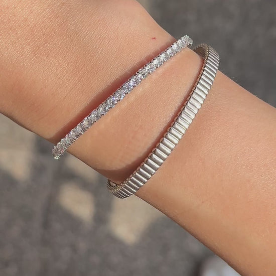 Model showing the seamless movement and pristine on-body fit of the flexible open-ended ribbed cuffs and the shine and striking stone of the lauren elastic bracelet during motion.