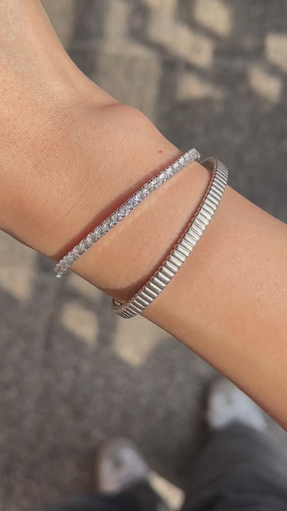 Model showing the seamless movement and pristine on-body fit of the flexible open-ended ribbed cuffs and the shine and striking stone of the lauren elastic bracelet during motion.