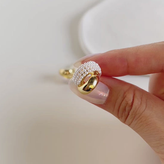 Contemporary luxury statement studs showcasing parallel gold and organic pearl tracks
