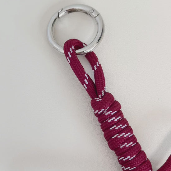 Premium monogram bag charm detailing a mirror polished square initial bead suspended on a central metal ring