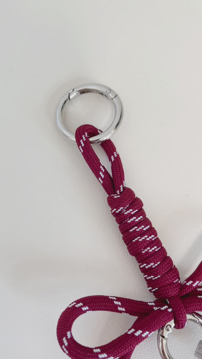 Premium monogram bag charm detailing a mirror polished square initial bead suspended on a central metal ring