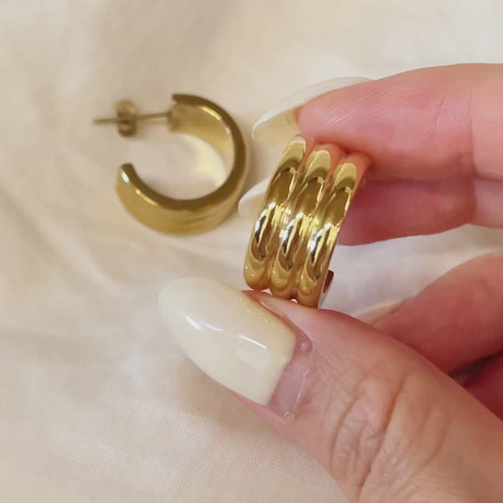 Macro detail of the Lucia triple-ridge hoop earring, emphasizing the high-end artisan craftsmanship and mirror-like surface coating.