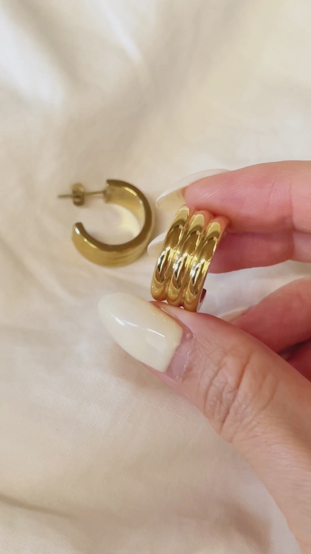 Macro detail of the Lucia triple-ridge hoop earring, emphasizing the high-end artisan craftsmanship and mirror-like surface coating.