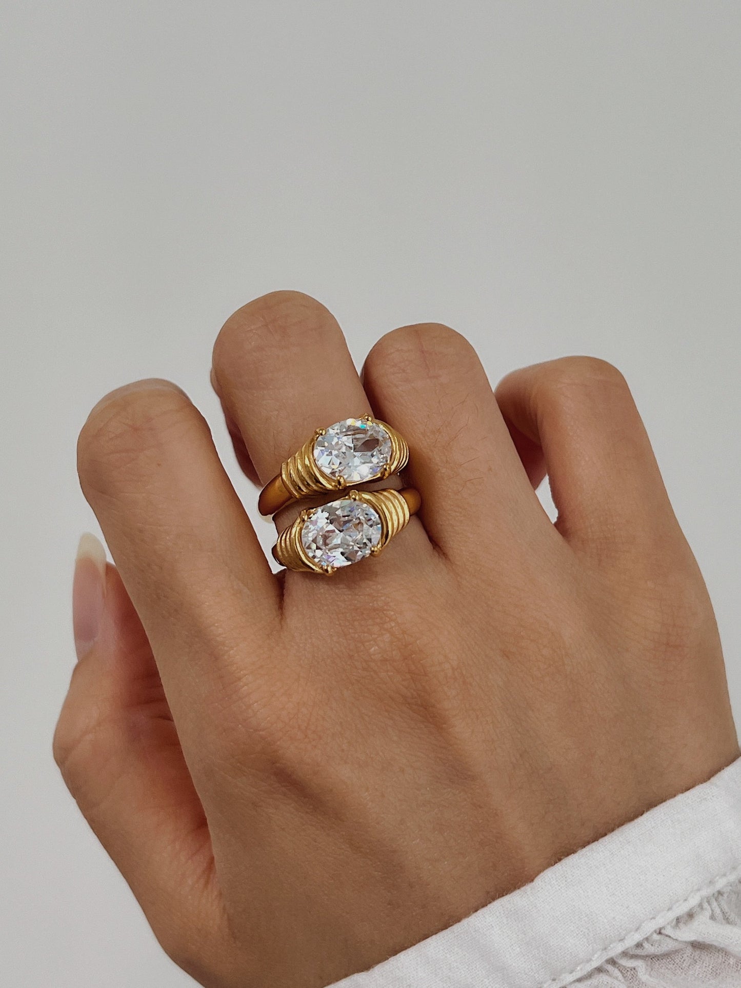 Modern jewelry stack featuring gold sparkle rings on hand