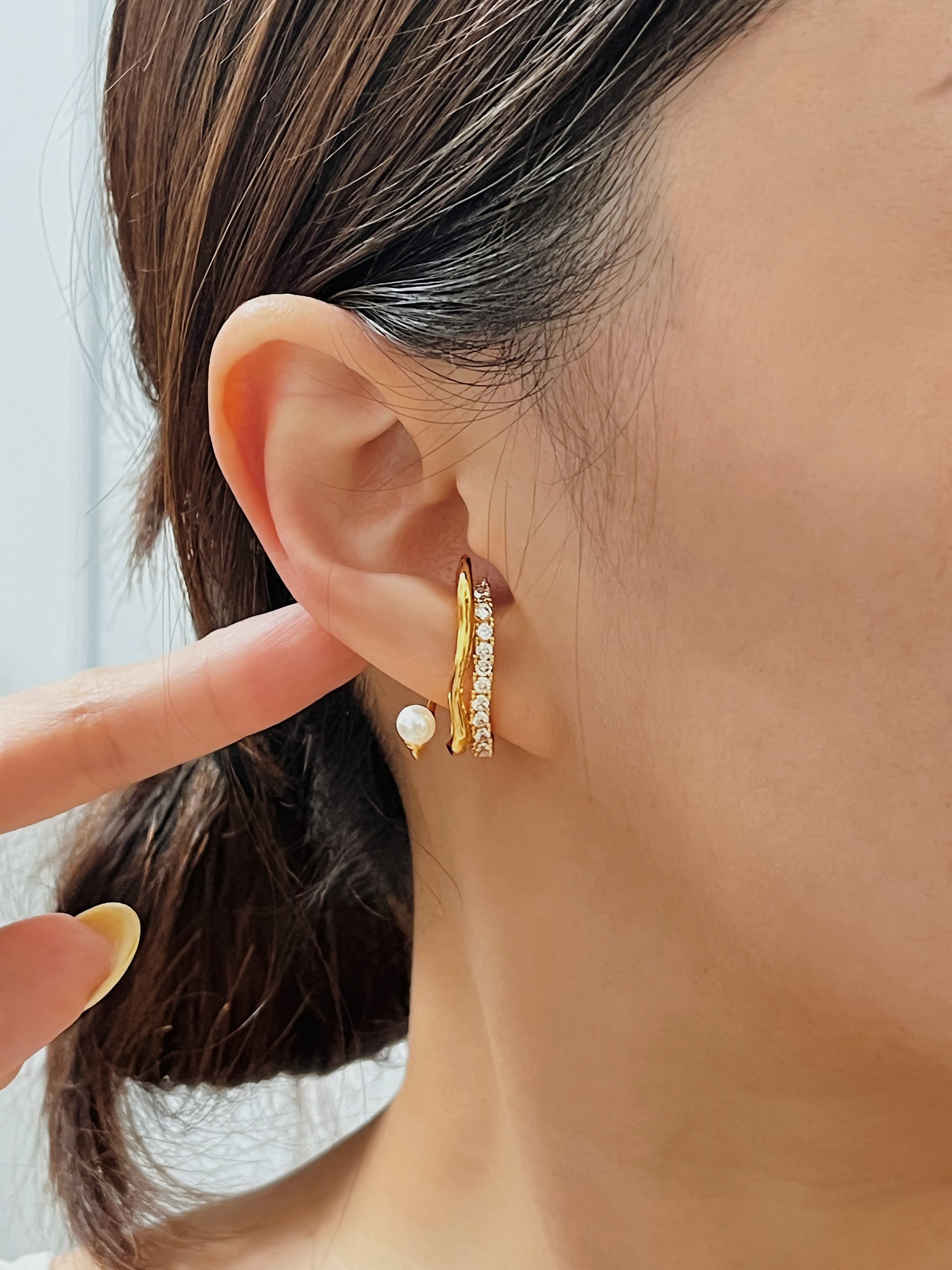 Side profile close-up of a model wearing the luxurious Cassidy Gold Pearl and Pave Crystal Cuff, showcasing its refined details against a subtle updo.