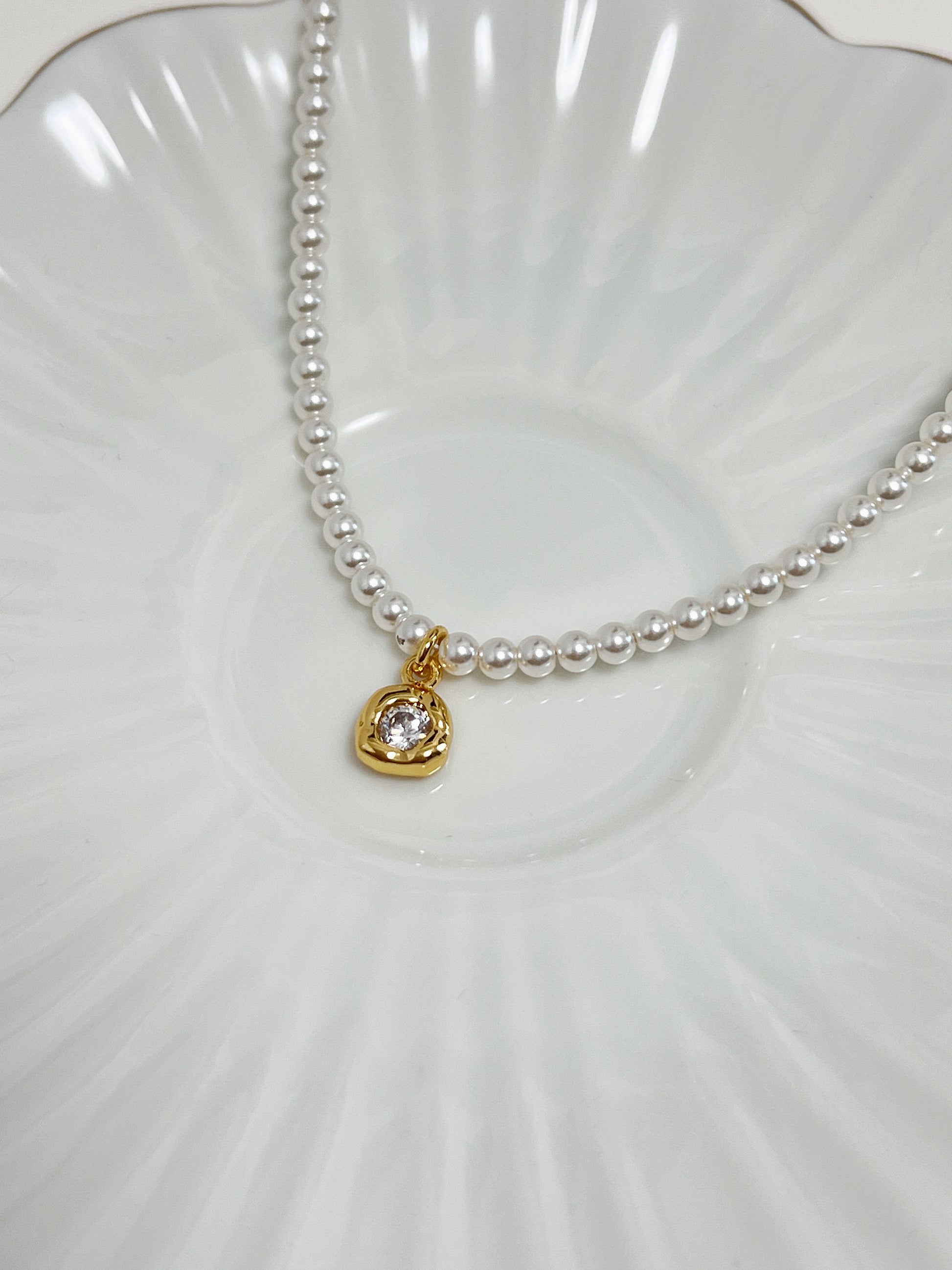 Aspirational lookbook image emphasizing a standalone cubic zirconia pearl pendant for a minimalist quiet luxury aesthetic