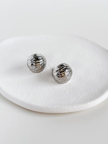 Side view of Mira Textured Dome Hoop Earrings in rippled silver finish