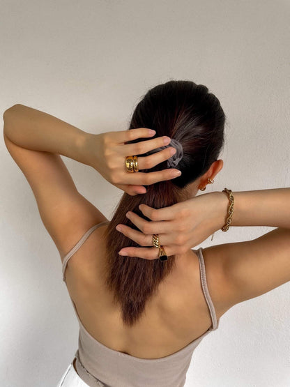 Editorial shot of gold ring stacks with a chunky bracelet