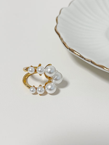 Architectural liquid gold pearl ring on a clean display surface