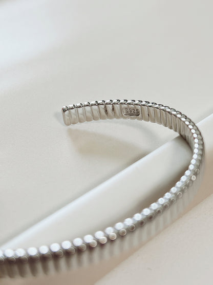 Macro product close-up highlighting the official s925 authenticity hallmark stamped on the smooth inner wall of the silver ribbed open cuff.
