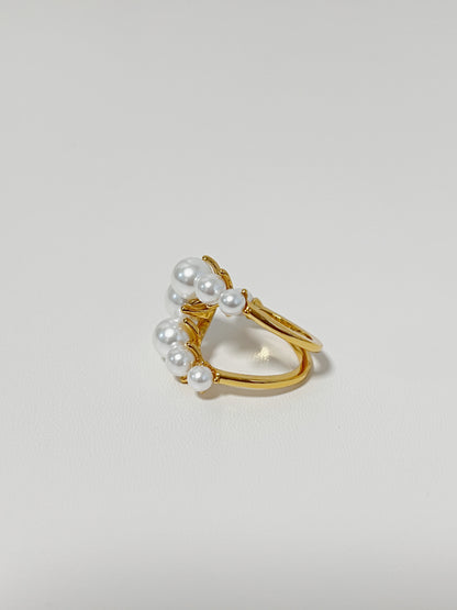Close-up of cascading multi-size cultured pearls on a fluid gold ring
