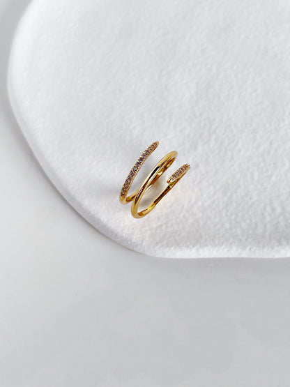 Architectural triple band effect gold ring on white surface
