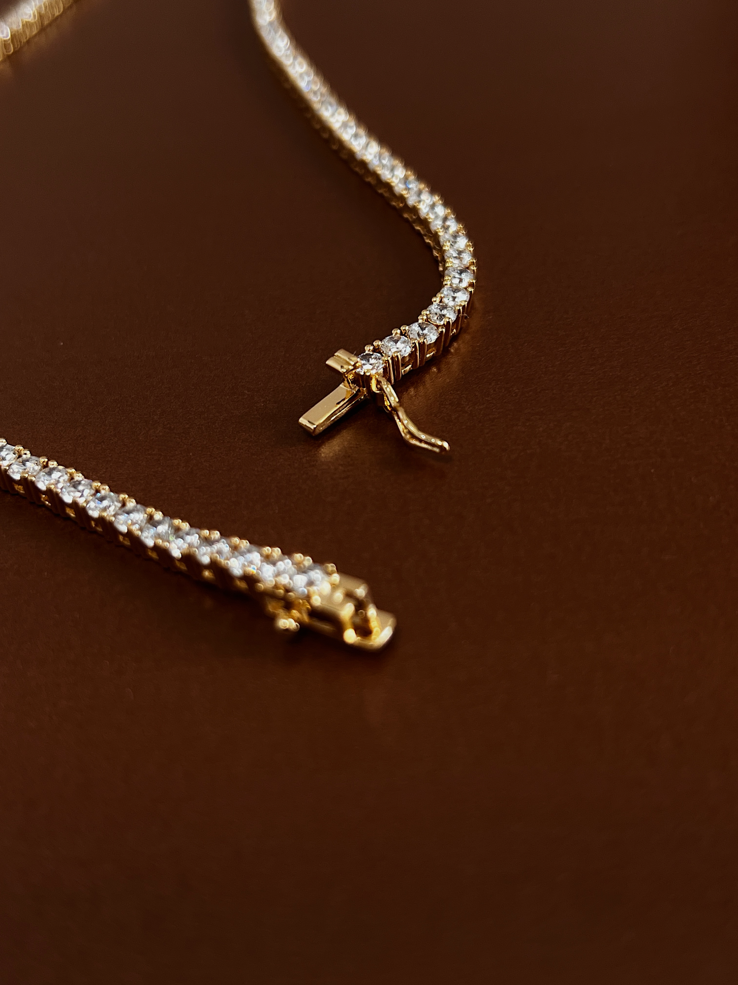 Integrated single latch safety box closure on a polished gold crystal chain