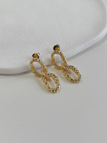 Side profile view of gold textured interlocking link drop earrings highlighting secure post stud closures