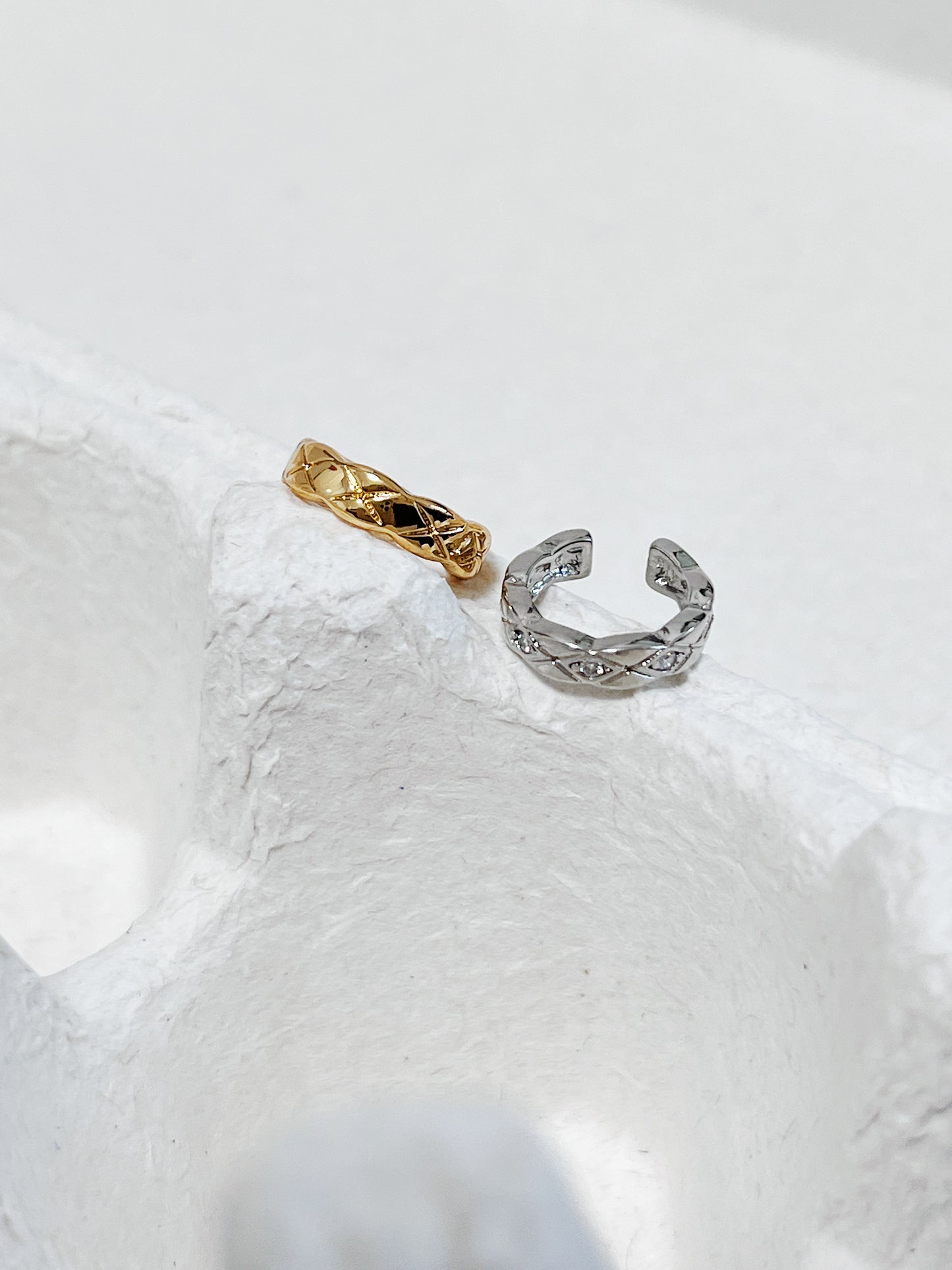Industrial Silver Louie Quilted Ear Cuff on white architectural stone.