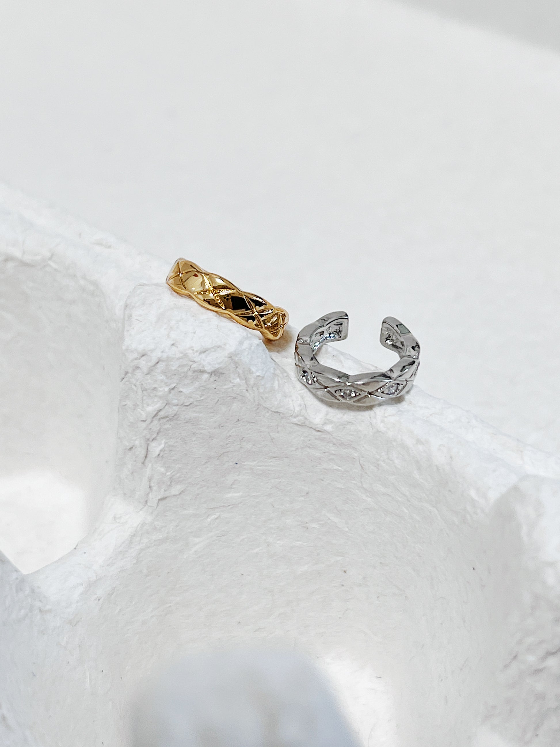 Industrial Silver Louie Quilted Ear Cuff on white architectural stone.