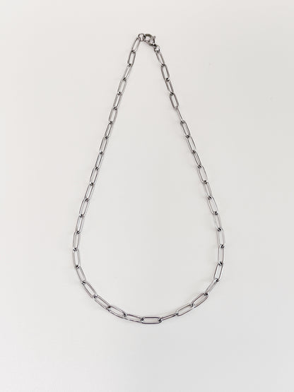 The 4mm thick silver paperclip link necklet laid out symmetrically to display its airy minimalist structural framework