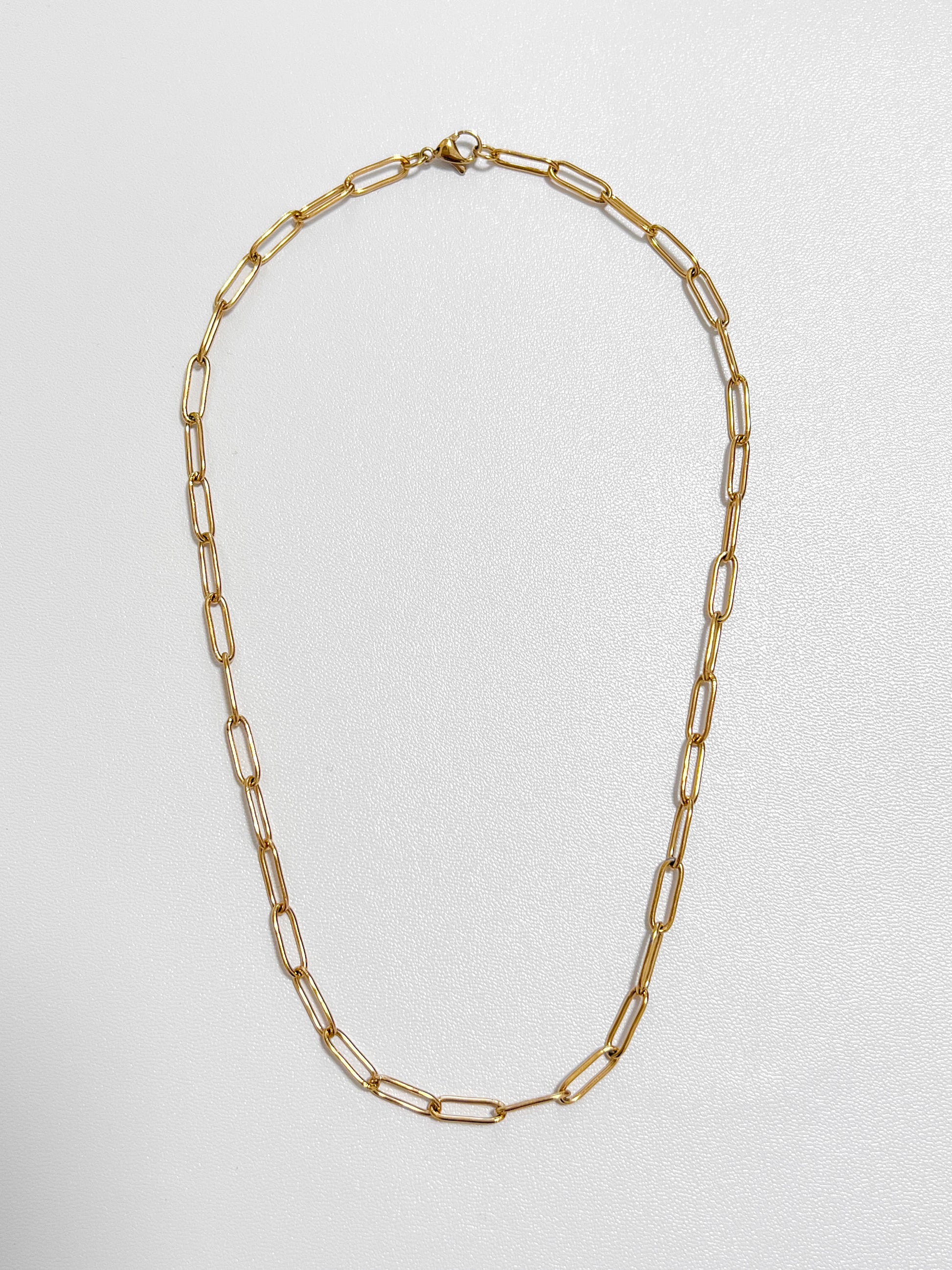 Overhead view of the Sofia paperclip chain necklace highlighting its 4mm flat elongated capsule loop profile on a white display
