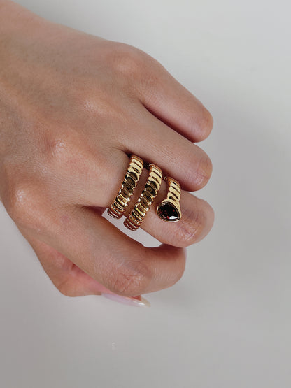 Statement ruby like gemstone ring reflecting natural light on model's hand