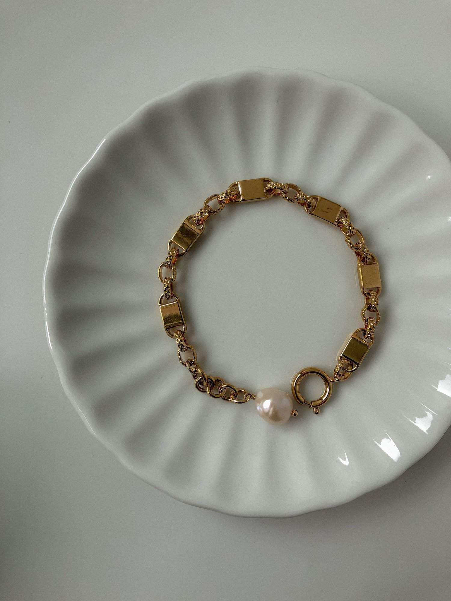 The Diana gold statement link bracelet arranged neatly on a luxury ceramic tray, emphasizing its smooth anti-snag finish.