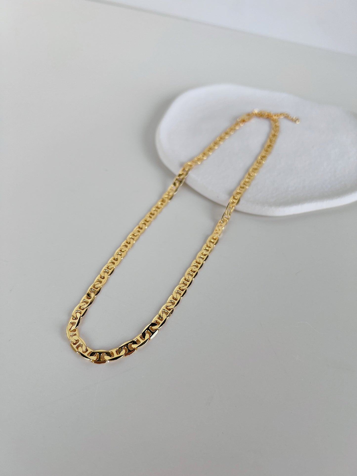 Still life presentation highlighting the supple fabric-like drape of a contemporary luxury geometric collar