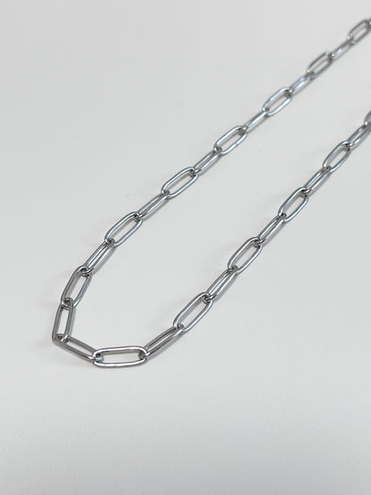 Still life presentation highlighting the supple fabric-like drape of a contemporary luxury paperclip collar chain