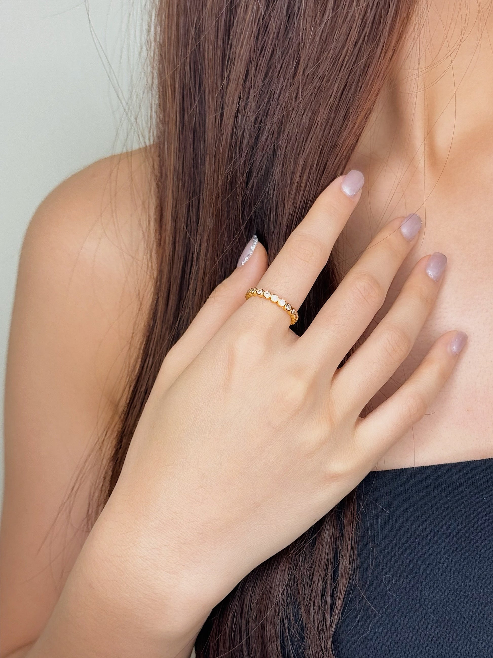 Womens hand showing a quiet luxury minimalist ring stack with a thin gold band