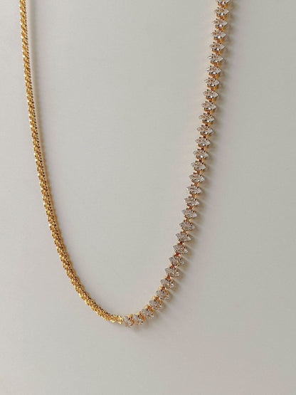 Close up view of pointed clear 5A cubic zirconia stones transitioning to brass chain links