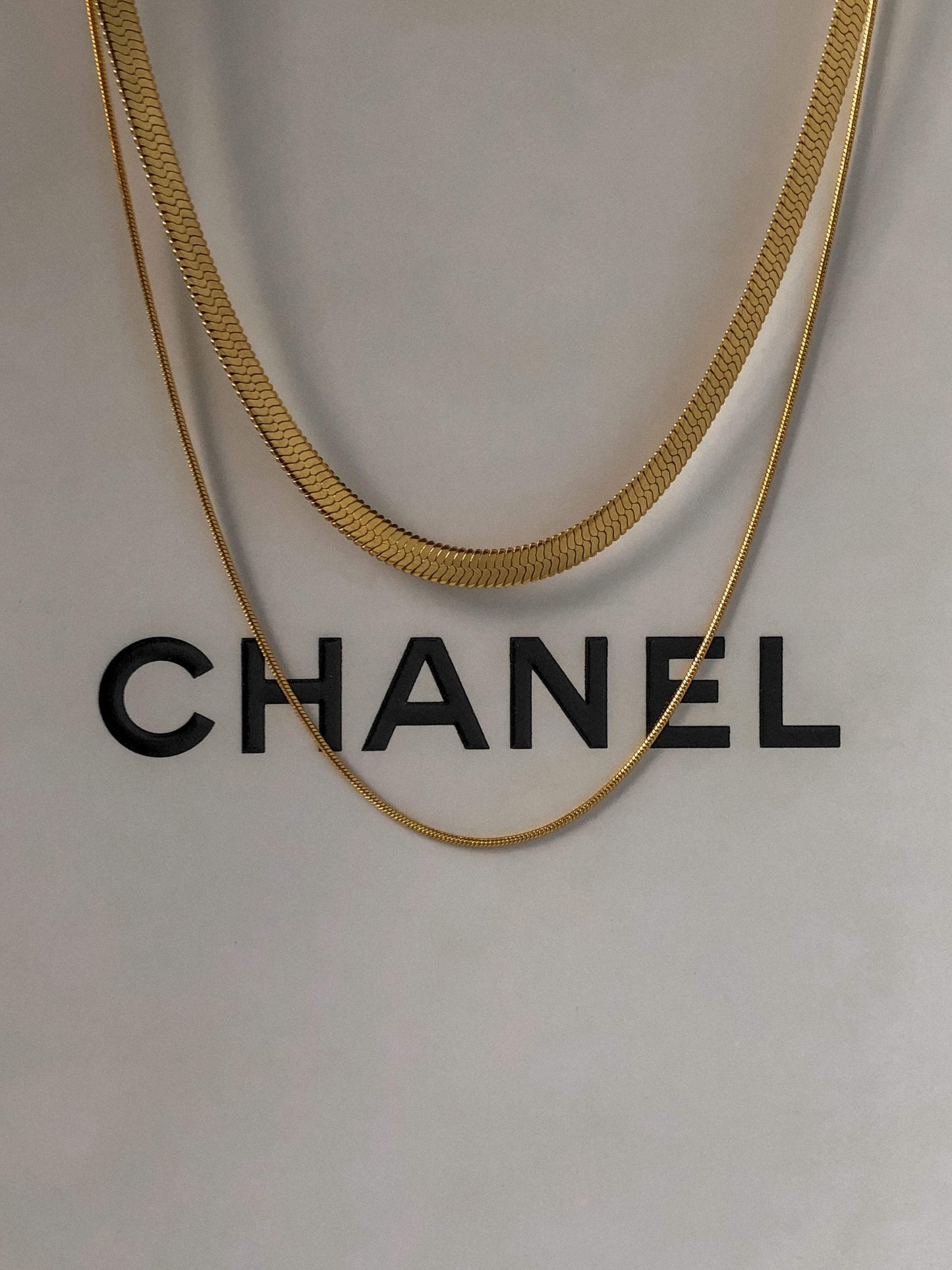 Close up view of high polish 18k gold PVD double tier flat snake chain necklace links