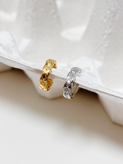 Macro view of Louie ear cuffs in gold and silver showing high-mirror finish.