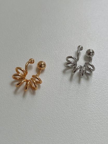 Close-up of gold Lis Spiral Ear Cuff showing the rhythmic coil and orbital end-caps.