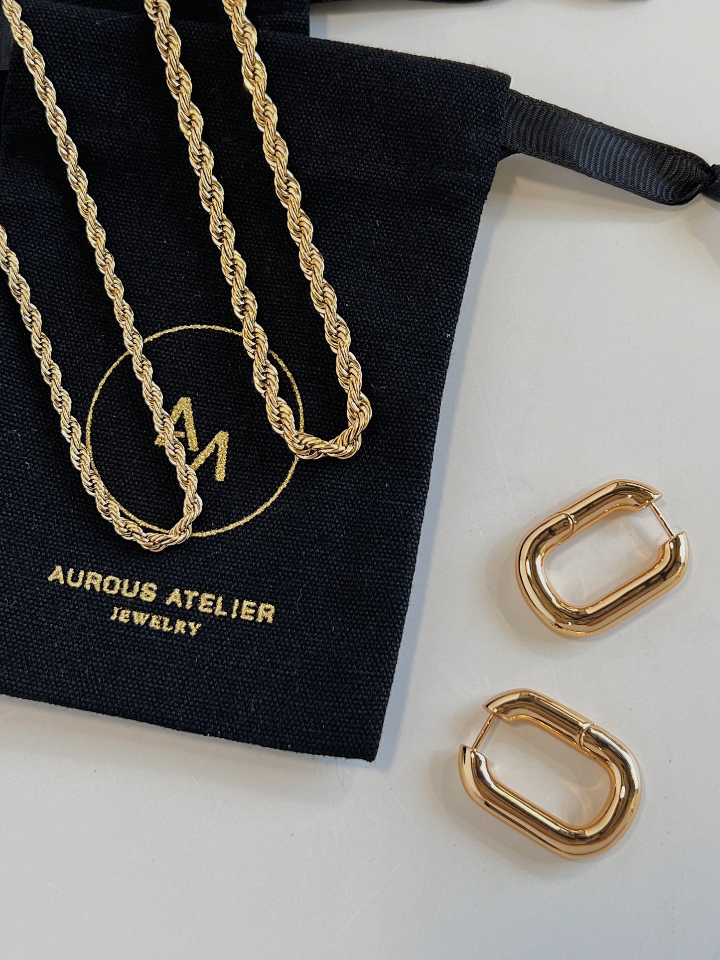 Elegant geometric braided cords arranged gracefully across black aurous atelier fabric pouch