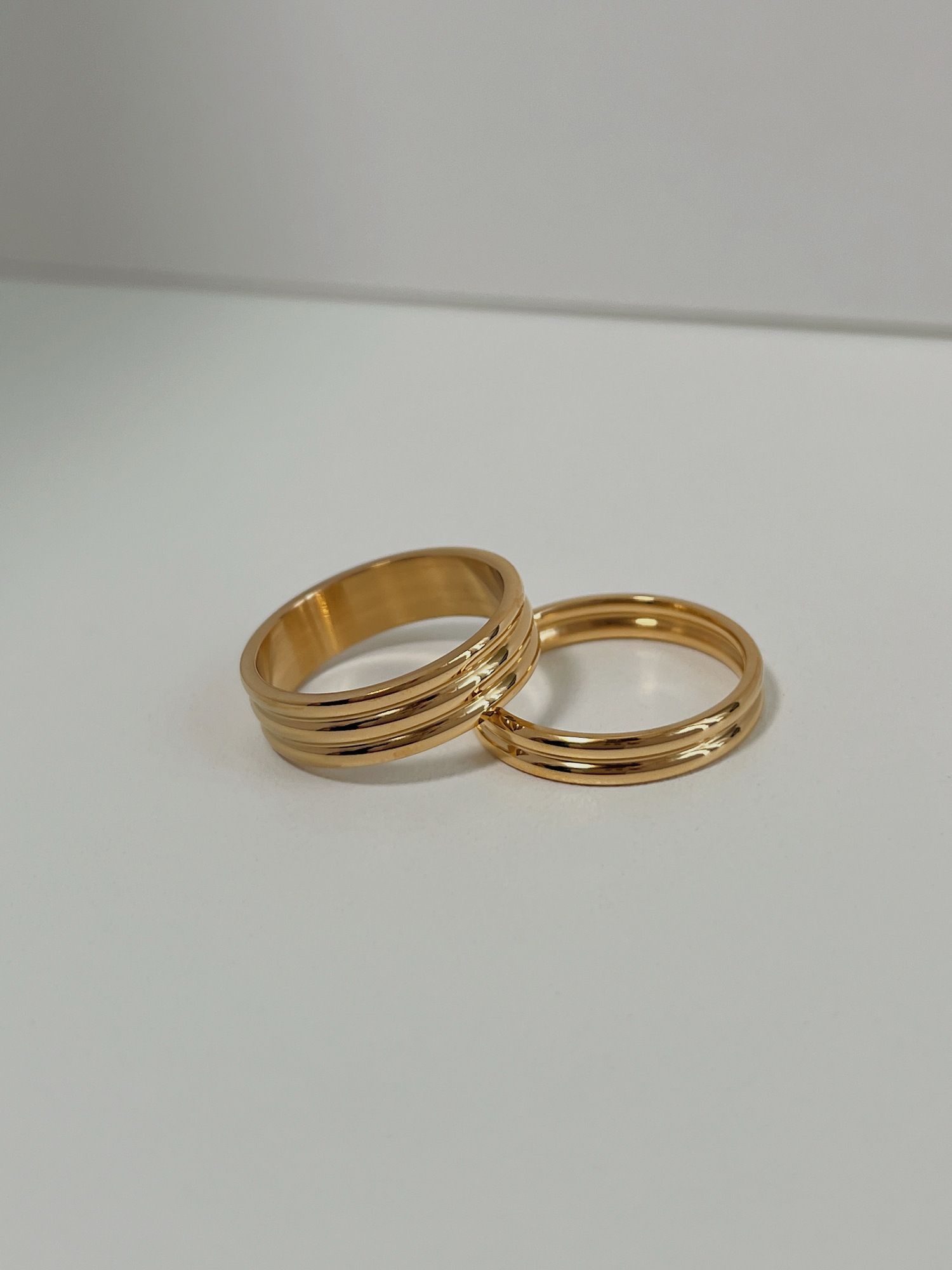 Comparison of slim and thick gold ribbed rings for stacking