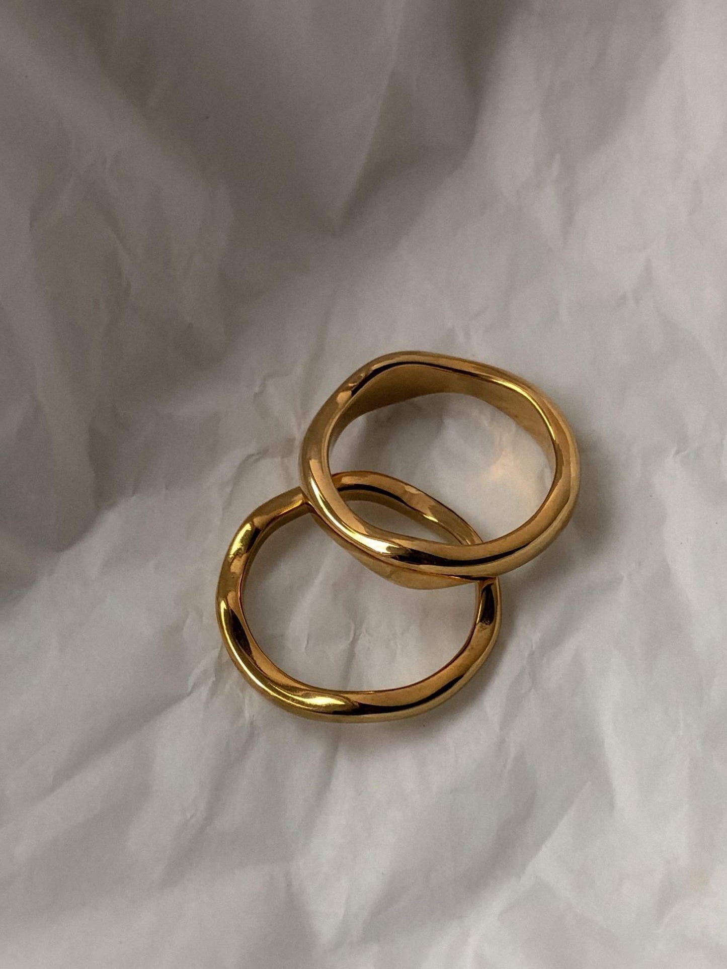 Ida thick and slim wavy gold band highlighting its liquid metal architecture.