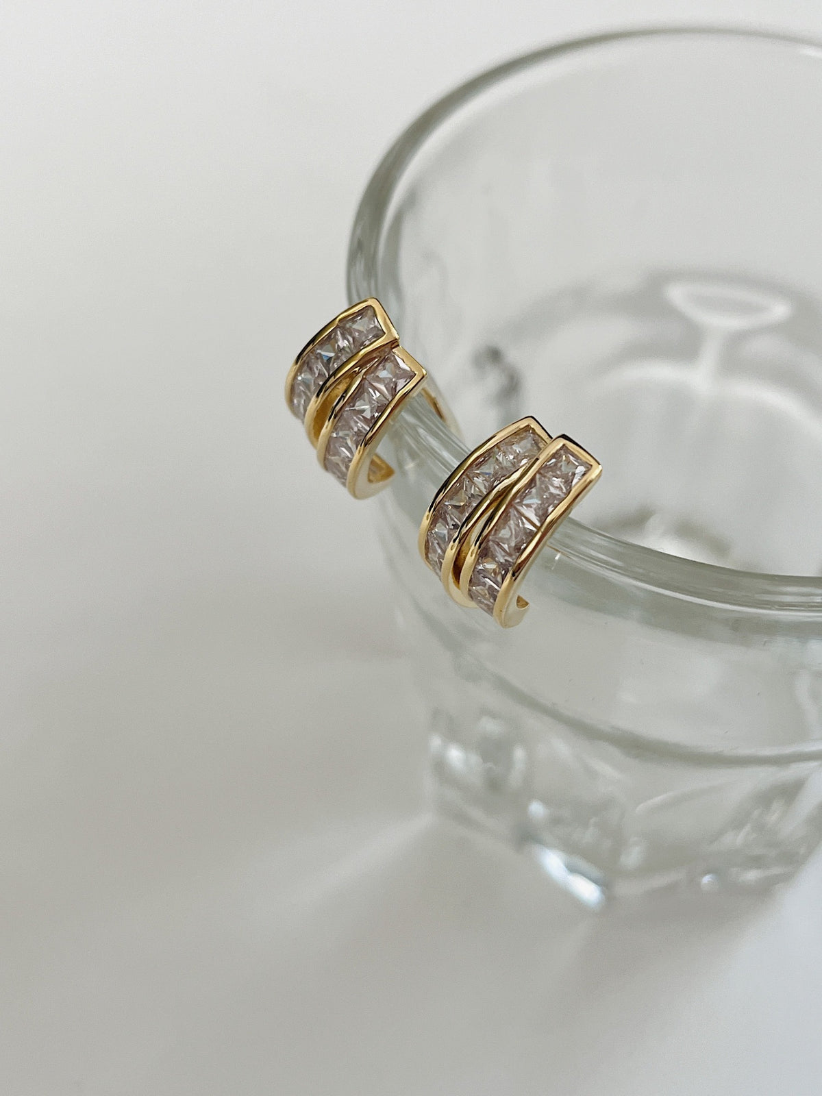 Tiana princess cut clip-on hoop paired on glass display stand