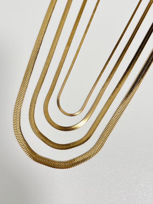 Parallel layout of flat herringbone chain necklaces highlighting the liquid mirror weave in different sizes