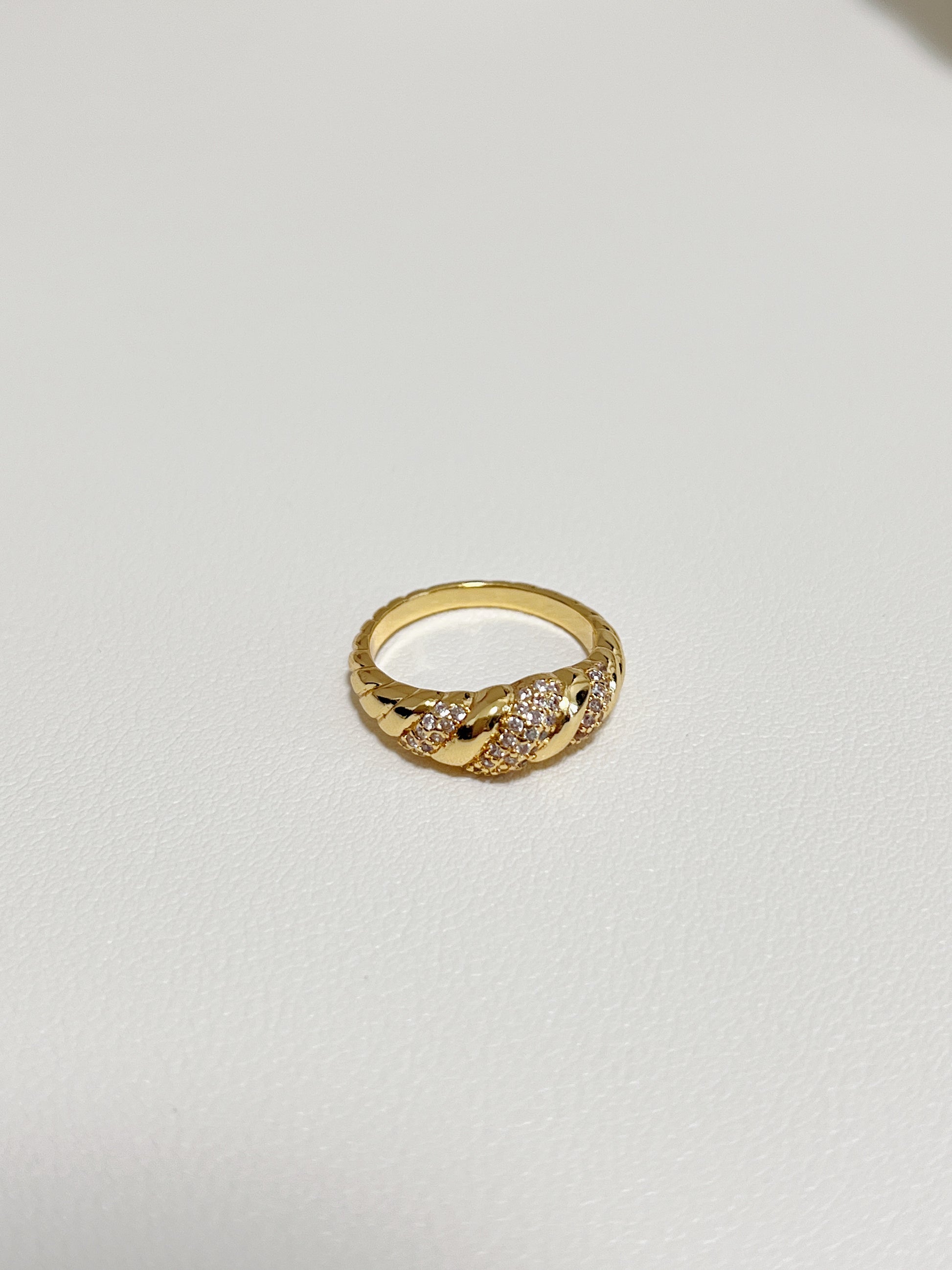 Close-up of the twisted croissant silhouette and pavé setting on the Claudia ring.