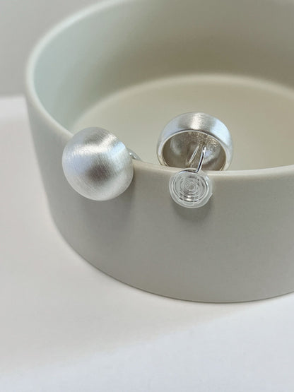 Close-up of invisible Japanese coil wire clip-on mechanism with clear silicone pad on silver Tyla dome