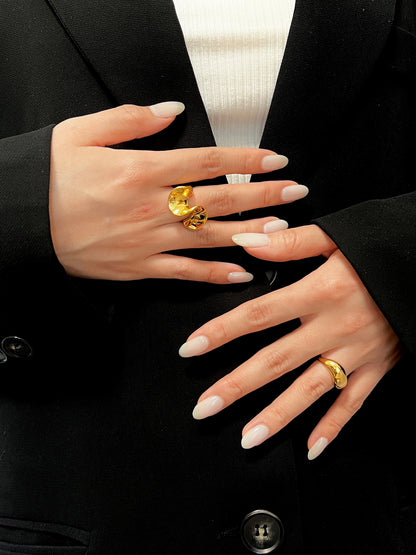 Close-up of model wearing thick gold statement band with a modern blazer
