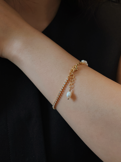 Rear perspective of the model's wrist showcasing the delicate gold extension chain and the signature freshwater pearl droplet detail hanging elegantly down, as referenced in the Vera bracelet design.