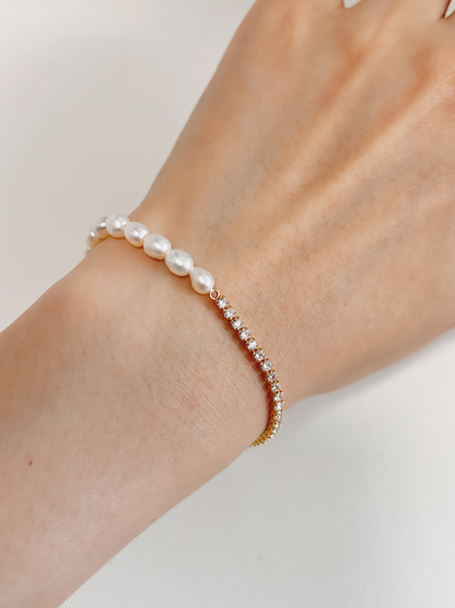 Macro model wrist capture highlighting the high-brilliance micro-set cubic zirconia stones and natural contours of the freshwater pearls catching natural afternoon light.