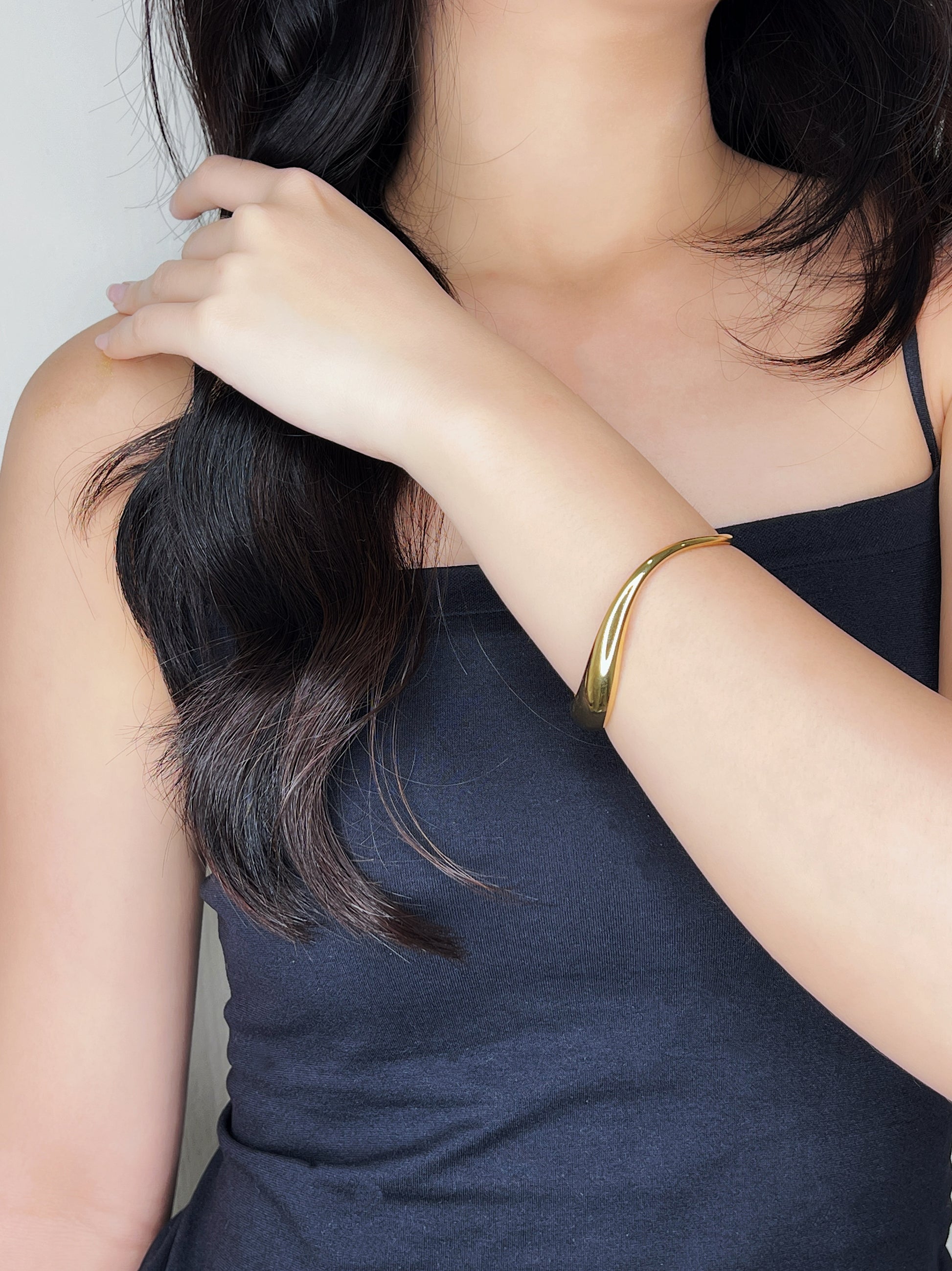 Model wearing the Vicky architectural gold cuff with a black top, showing a high-end, quiet luxury style.