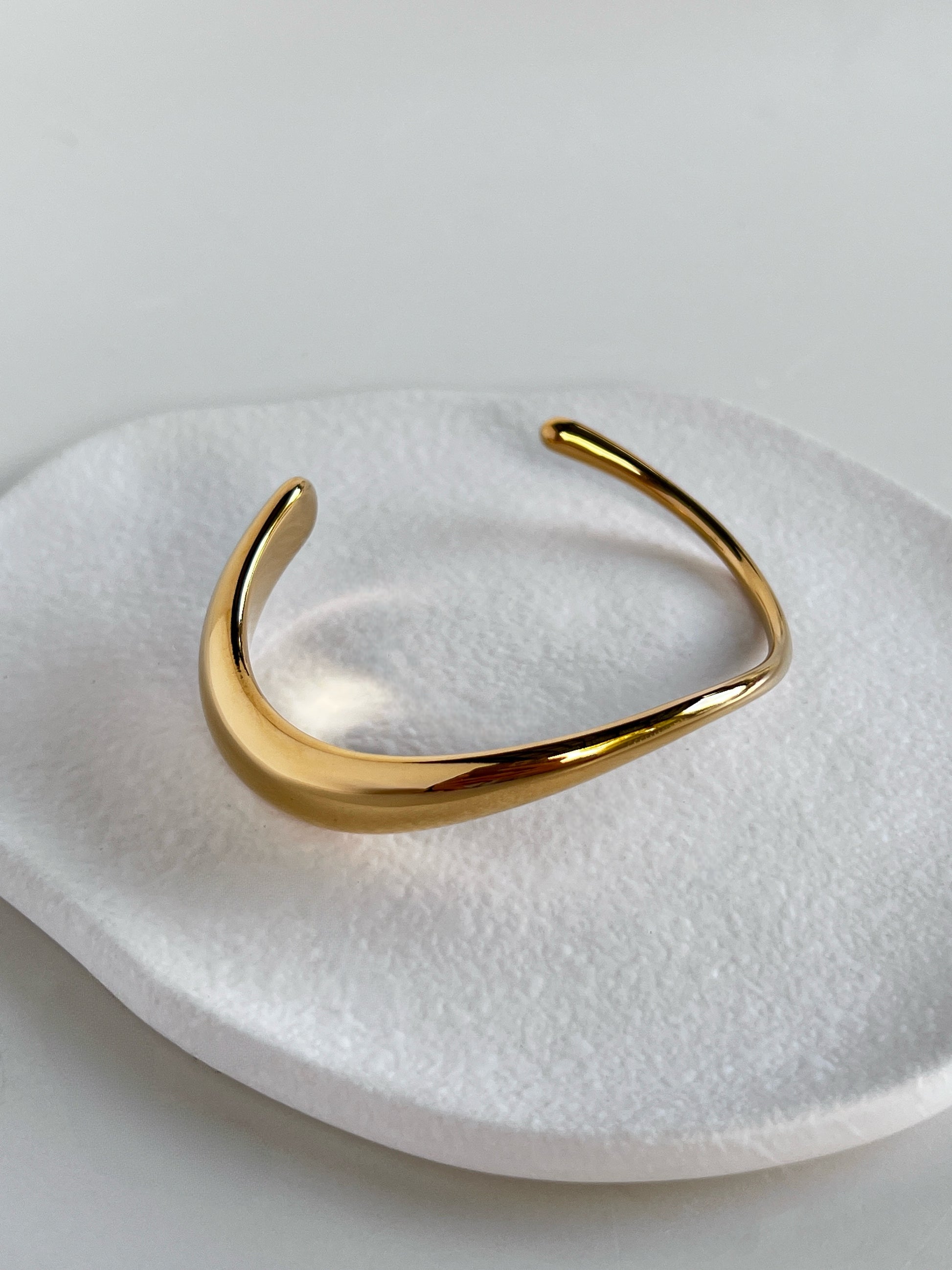 Top-down view of the Vicky sculpted cuff, emphasizing the firm, non-adjustable continuous structural band and seamless gold finishing.