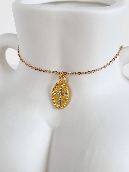 Detailed macro shot of the vintage beaded border and textured gold center of the Gianna medallion necklace resting on a white ceramic body sculpture
