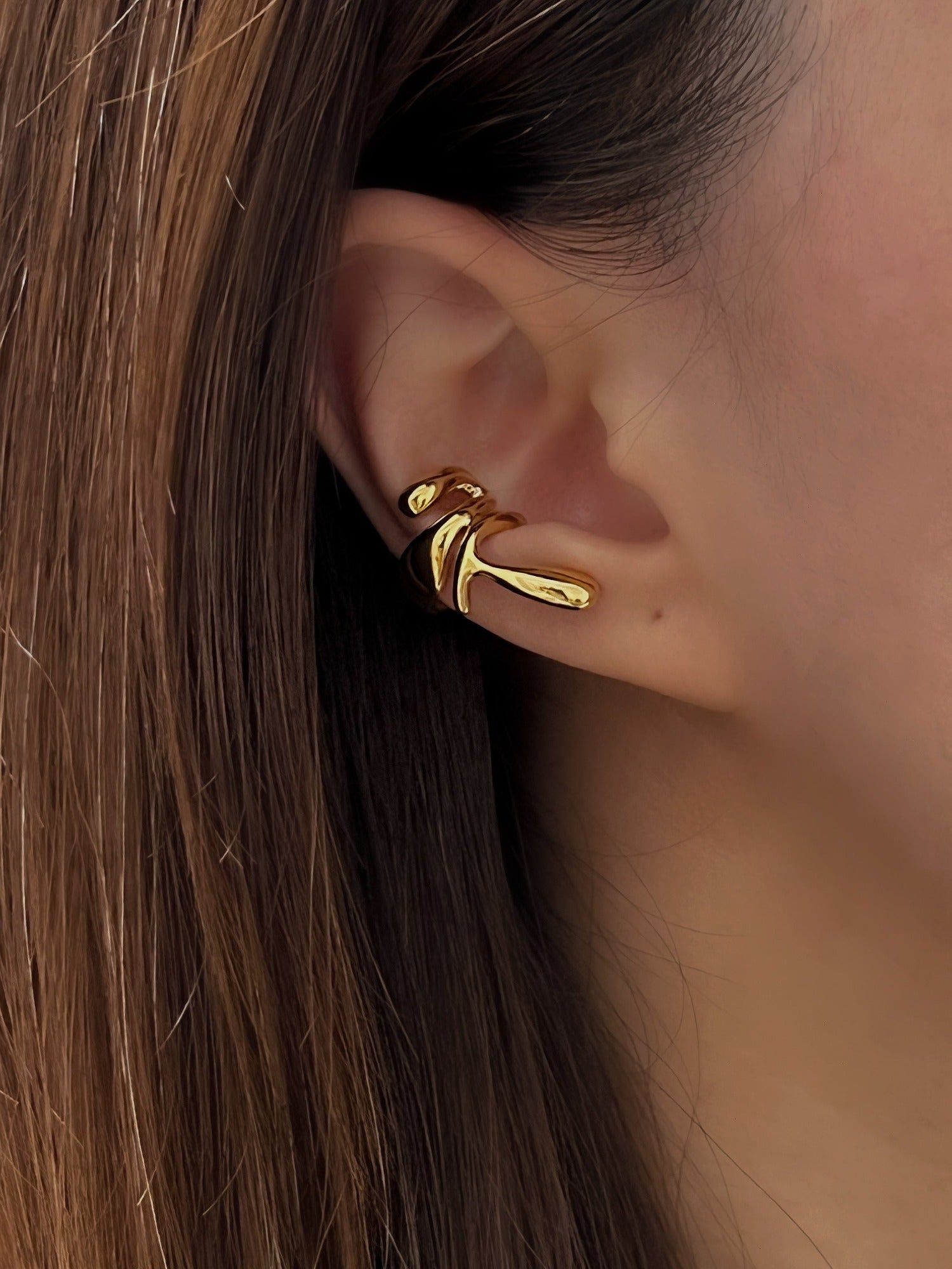 Quiet luxury ear curation on a model featuring the Dylan 18K gold PVD cuff.