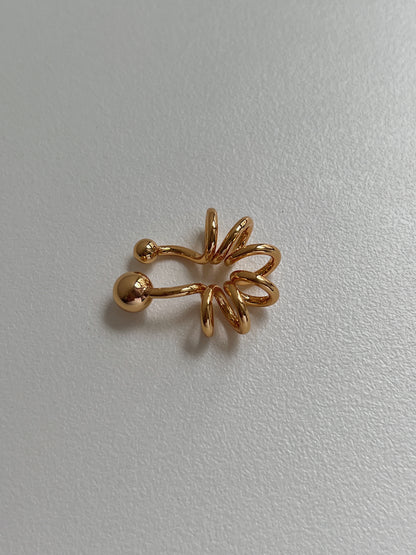 Side view showing the tubular spiral design of the 18K gold PVD cuff.