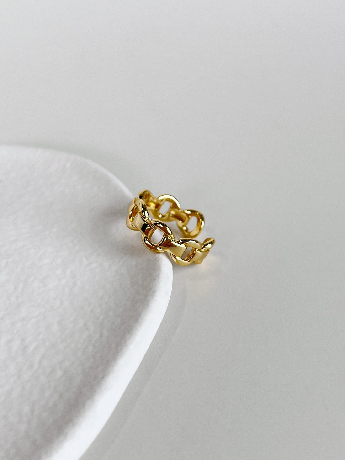 Top view of the interlocking fluid chain curves on the gold link ring