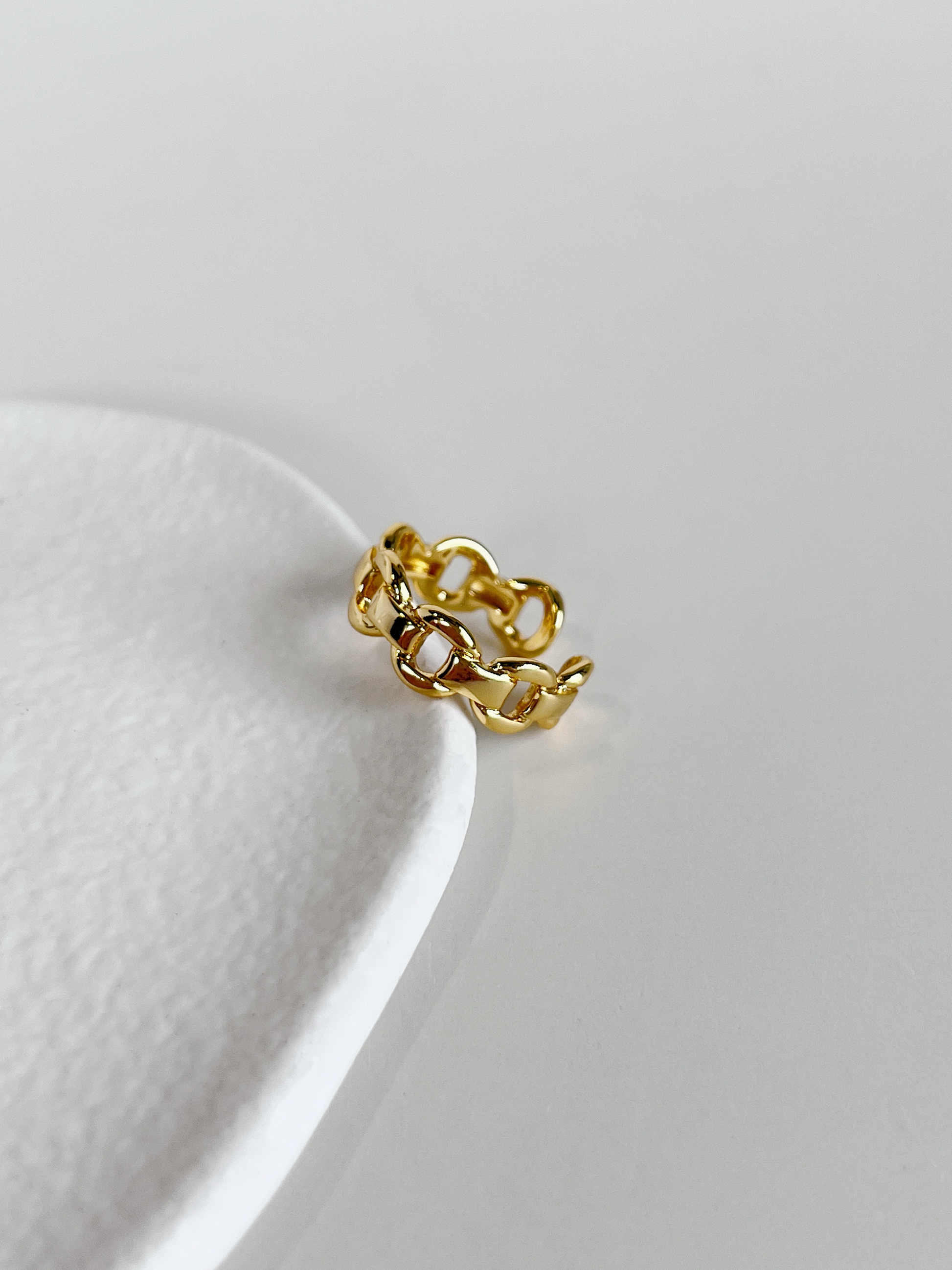 Top view of the interlocking fluid chain curves on the gold link ring