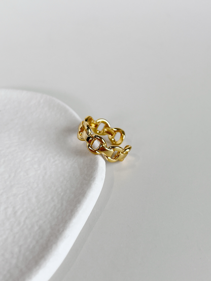 Top view of the interlocking fluid chain curves on the gold link ring